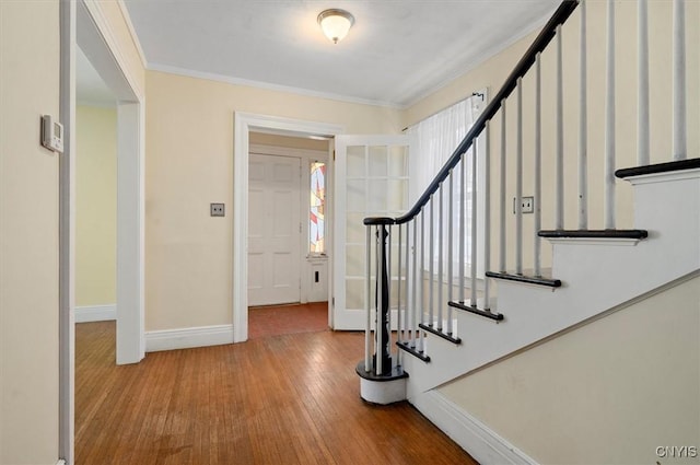 entryway featuring ornamental molding and light wood-type flooring