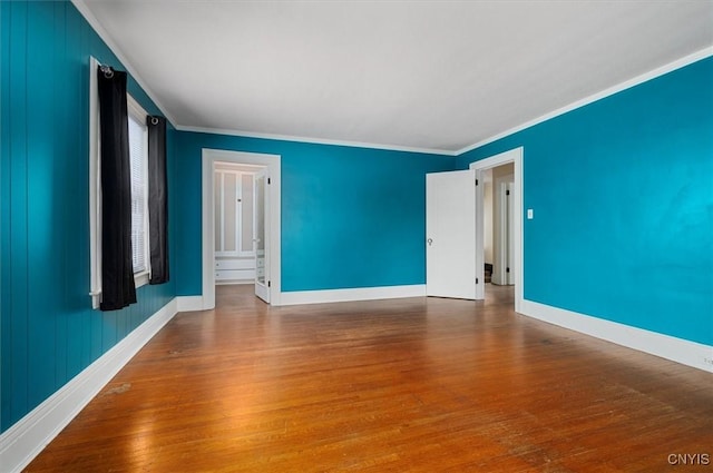 empty room with ornamental molding and hardwood / wood-style flooring