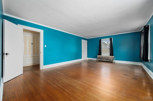 unfurnished living room with hardwood / wood-style flooring, radiator, and ornamental molding