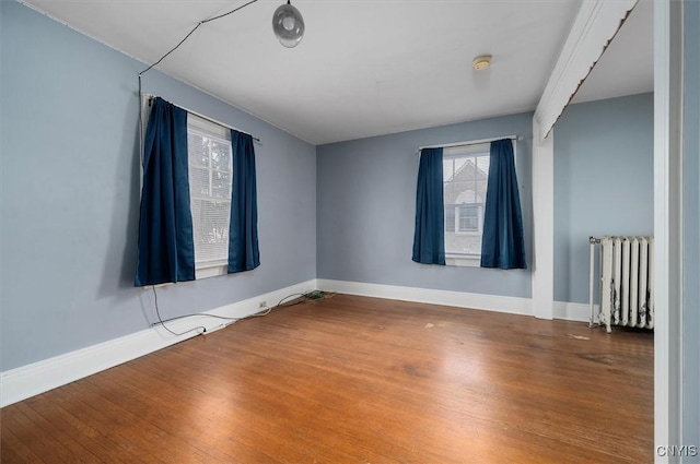 unfurnished room with radiator and hardwood / wood-style flooring