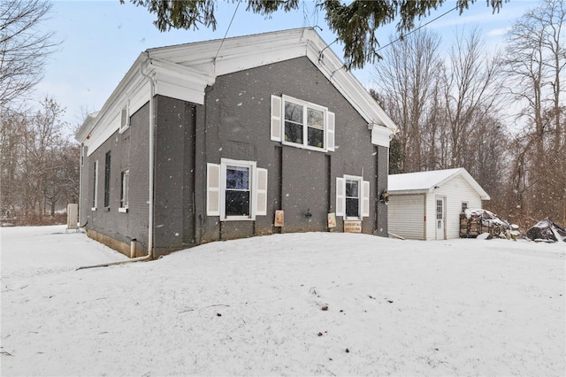 snow covered property featuring a storage unit