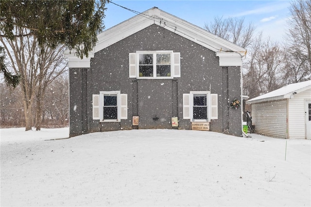 snow covered house featuring an outdoor structure