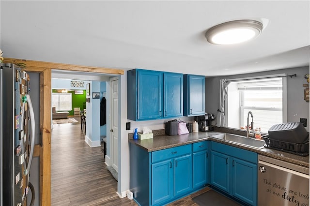 kitchen featuring blue cabinets, sink, dark wood-type flooring, and stainless steel appliances