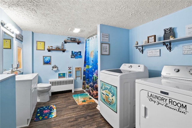 laundry area featuring washing machine and dryer, dark hardwood / wood-style floors, radiator heating unit, and a textured ceiling