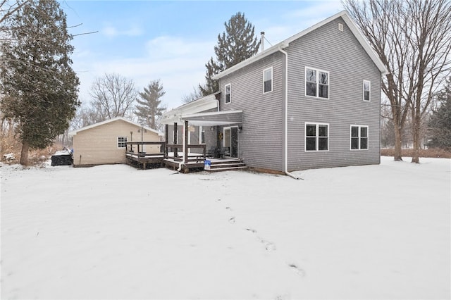 snow covered rear of property featuring a wooden deck