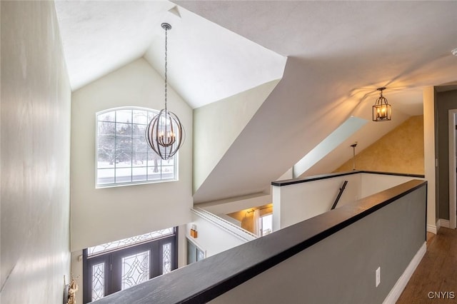 interior space with vaulted ceiling, dark wood-type flooring, and an inviting chandelier