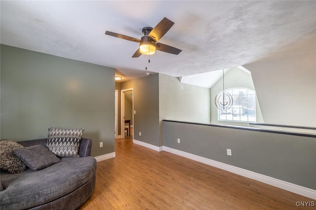 sitting room featuring vaulted ceiling, ceiling fan with notable chandelier, and light hardwood / wood-style flooring