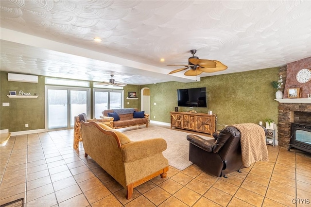 tiled living room featuring ceiling fan and an AC wall unit