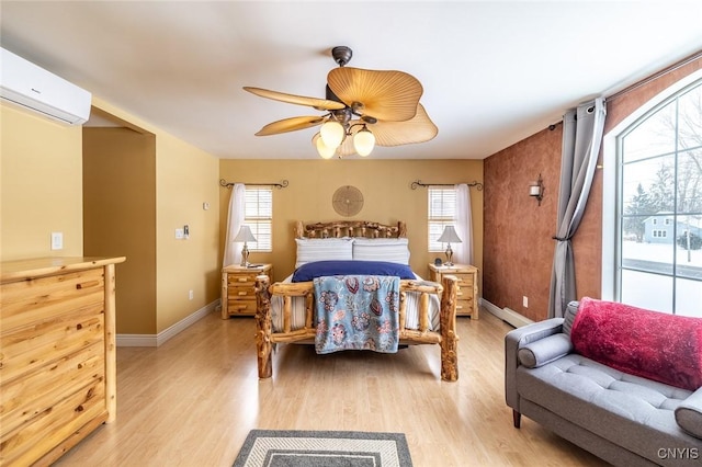 bedroom featuring light wood-type flooring, ceiling fan, and a wall mounted AC