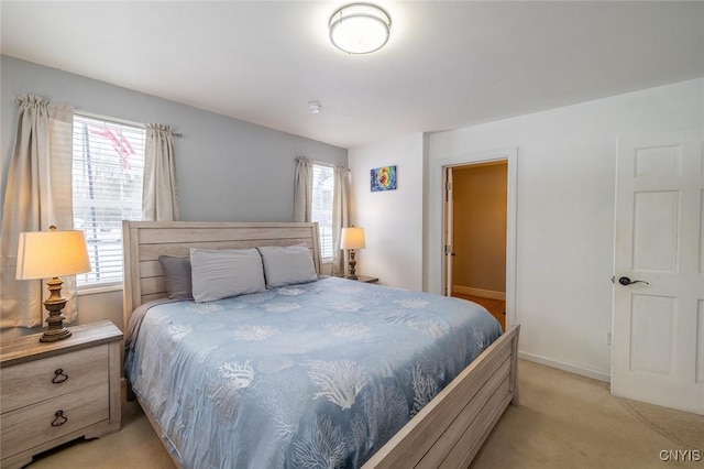 bedroom with light colored carpet and multiple windows