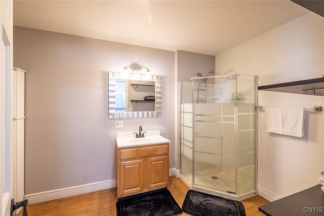 bathroom with wood-type flooring, walk in shower, and vanity