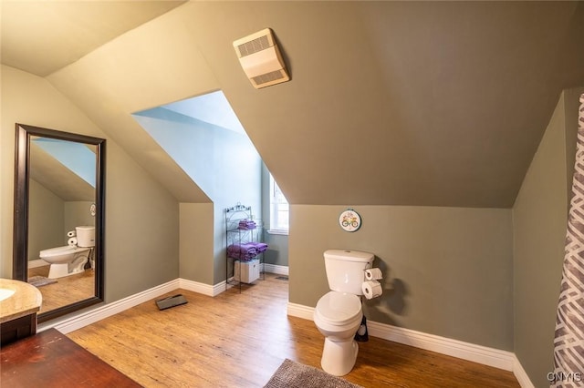 bathroom featuring toilet, vaulted ceiling, and hardwood / wood-style flooring