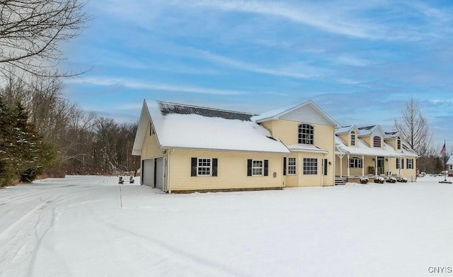 snow covered property with a garage