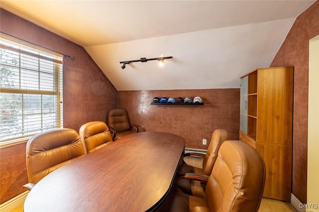 dining space featuring baseboard heating, lofted ceiling, and light hardwood / wood-style flooring