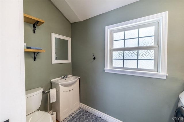 bathroom featuring toilet, lofted ceiling, and vanity