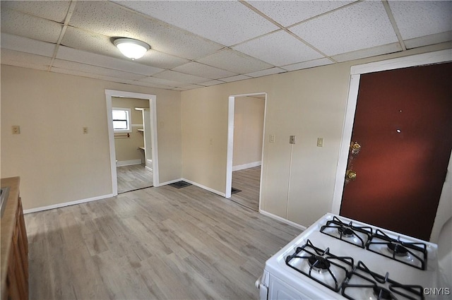 kitchen featuring a drop ceiling, hardwood / wood-style flooring, and white range with gas cooktop