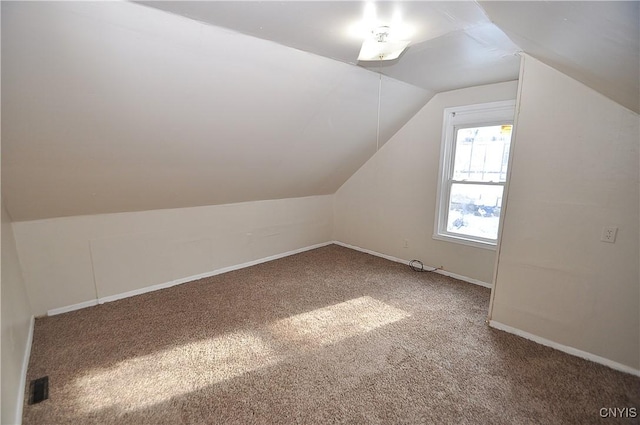 additional living space featuring vaulted ceiling and carpet flooring