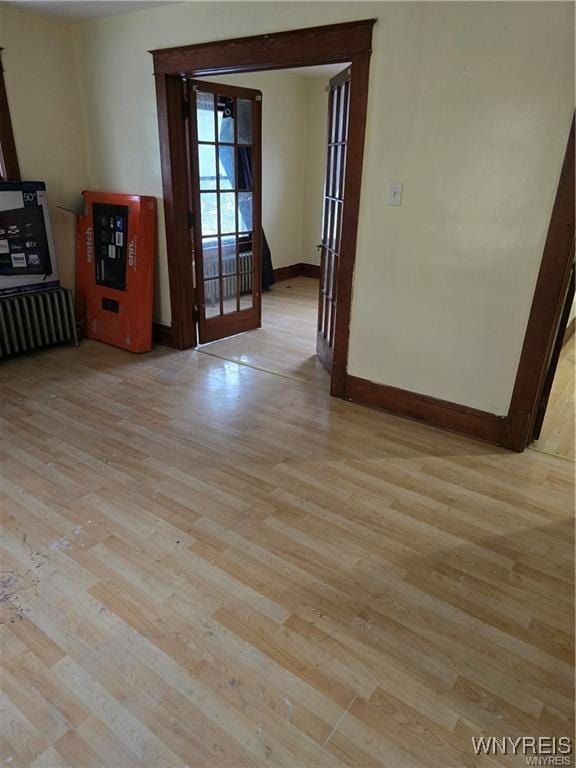 spare room with light hardwood / wood-style floors and french doors