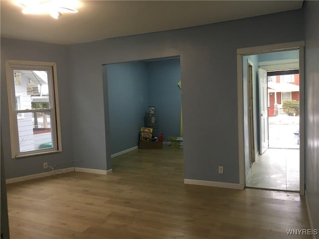 unfurnished room with a wealth of natural light and wood-type flooring