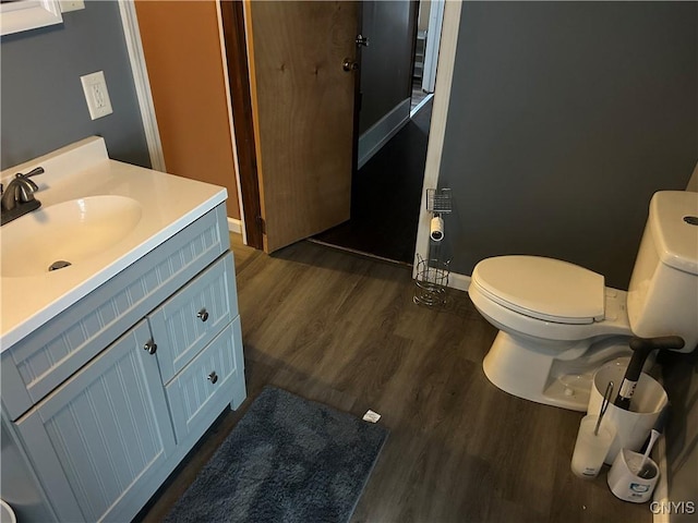 bathroom featuring toilet, hardwood / wood-style flooring, and vanity