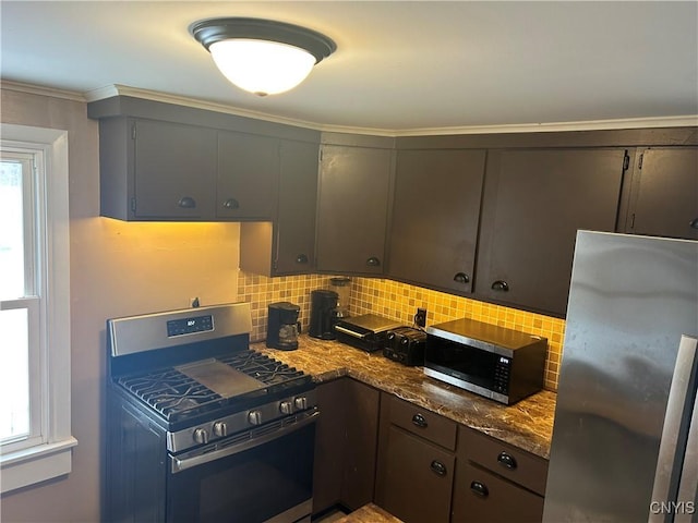 kitchen featuring decorative backsplash, dark stone counters, stainless steel appliances, and ornamental molding