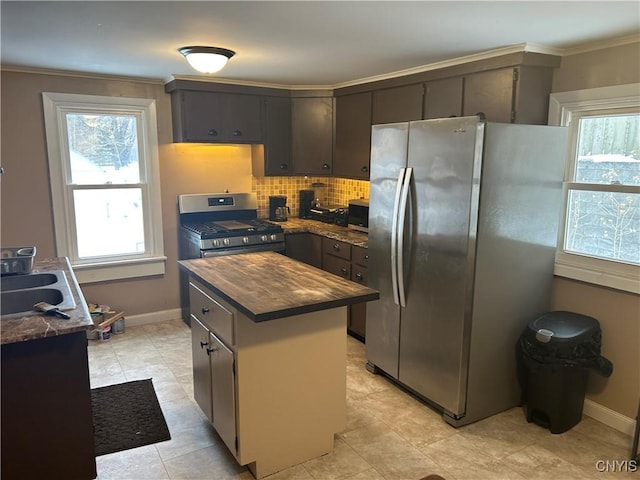 kitchen with butcher block countertops, appliances with stainless steel finishes, sink, crown molding, and a center island