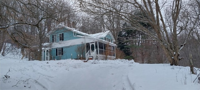 snow covered property featuring a sunroom