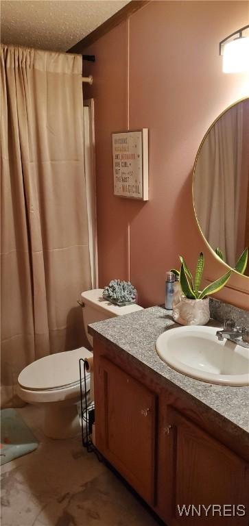 bathroom featuring vanity, a textured ceiling, curtained shower, and toilet