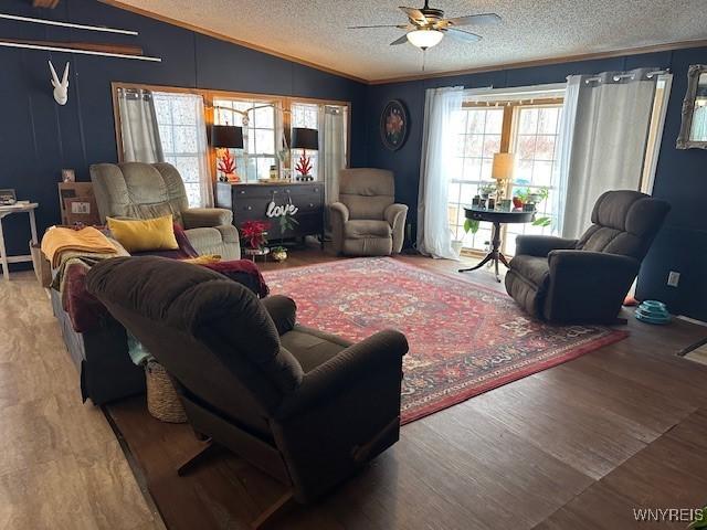 living room with hardwood / wood-style flooring, lofted ceiling, and ceiling fan