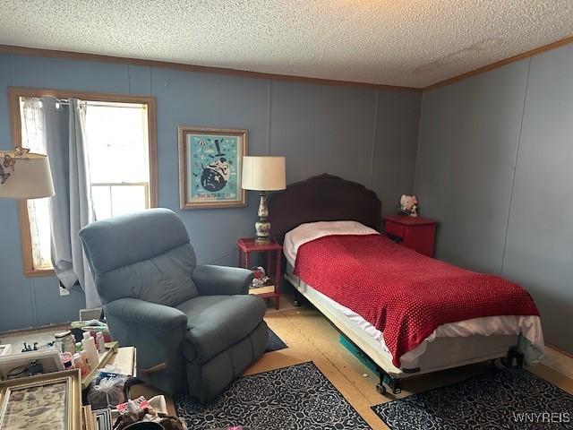 bedroom with light hardwood / wood-style floors and a textured ceiling