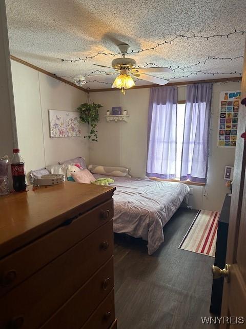 bedroom featuring ceiling fan, ornamental molding, hardwood / wood-style floors, and a textured ceiling