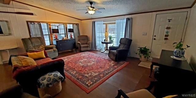 living room featuring hardwood / wood-style flooring, ceiling fan, vaulted ceiling, and a textured ceiling