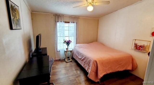 bedroom with wood-type flooring, ceiling fan, and a textured ceiling