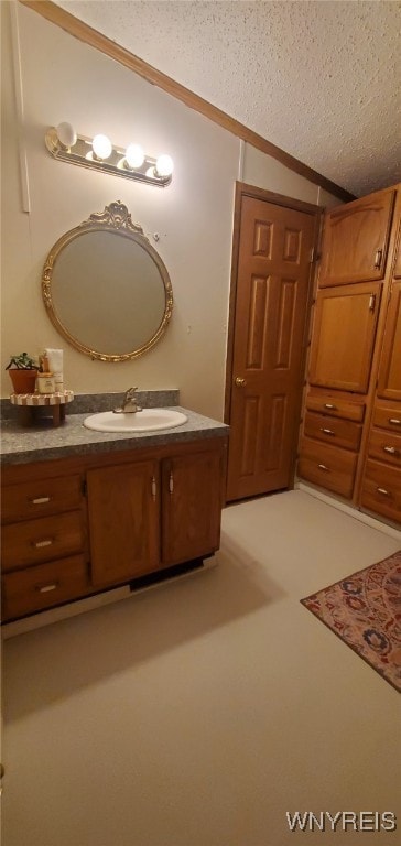 bathroom featuring vanity, lofted ceiling, and a textured ceiling