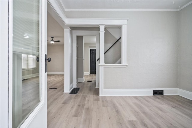 empty room featuring ceiling fan, crown molding, and light hardwood / wood-style floors