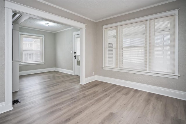 foyer with a textured ceiling, crown molding, and light hardwood / wood-style floors