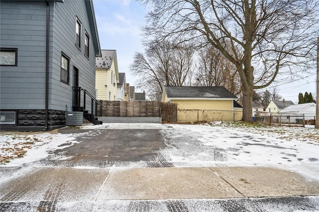 snowy yard featuring central AC