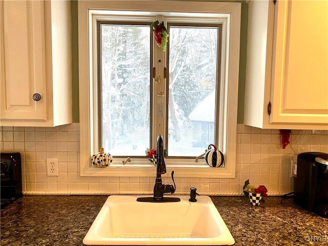 kitchen with plenty of natural light, sink, white cabinets, and decorative backsplash