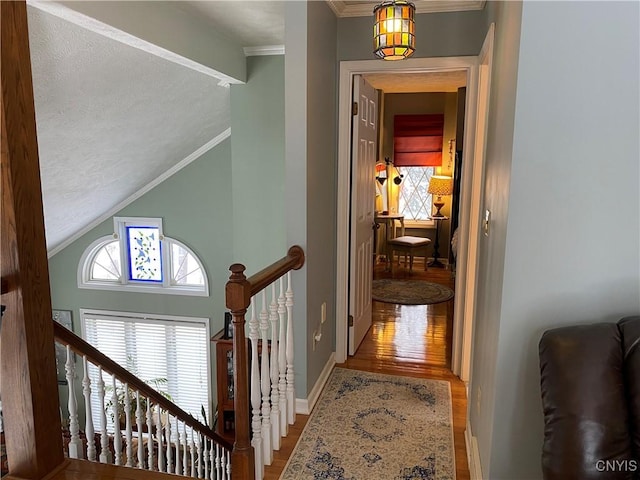 hallway featuring crown molding, lofted ceiling, and wood-type flooring