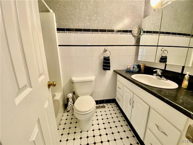 full bathroom featuring shower / tub combo with curtain, tile walls, vanity, tile patterned floors, and toilet