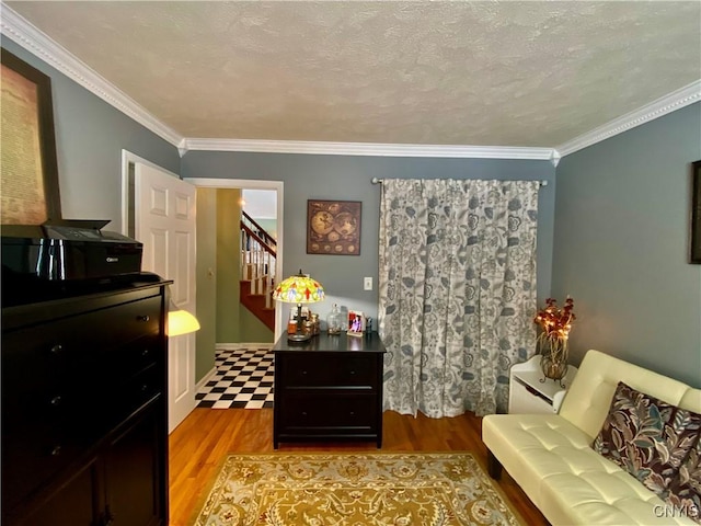 living area featuring crown molding, a textured ceiling, and light hardwood / wood-style flooring