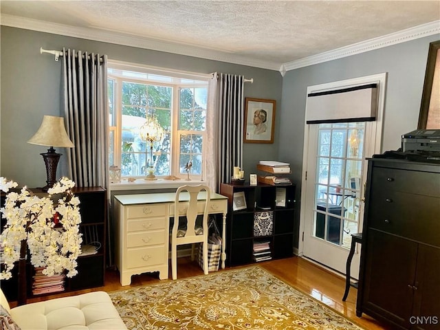 office space with ornamental molding, light wood-type flooring, and a textured ceiling