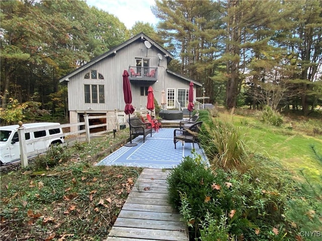 back of property featuring a balcony and a patio