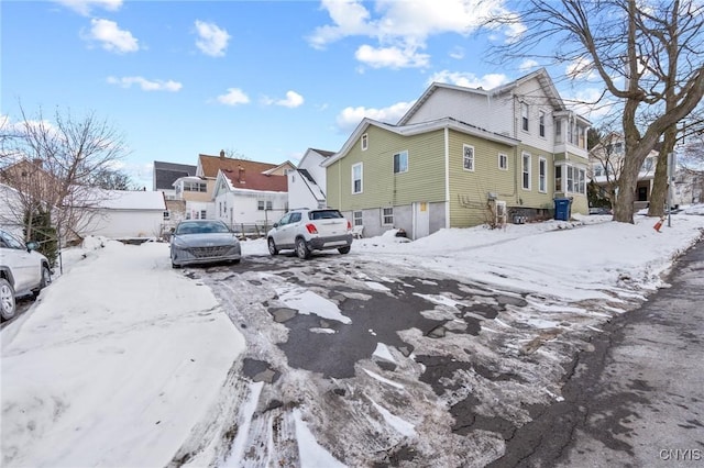 snow covered property with an attached garage and a residential view