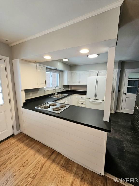 kitchen with crown molding, sink, white cabinets, and white appliances