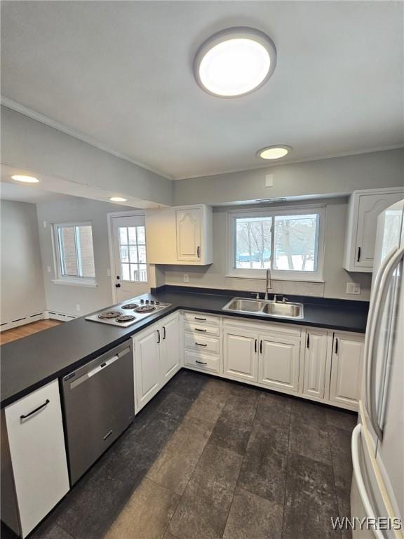 kitchen featuring kitchen peninsula, white appliances, a baseboard radiator, white cabinets, and sink