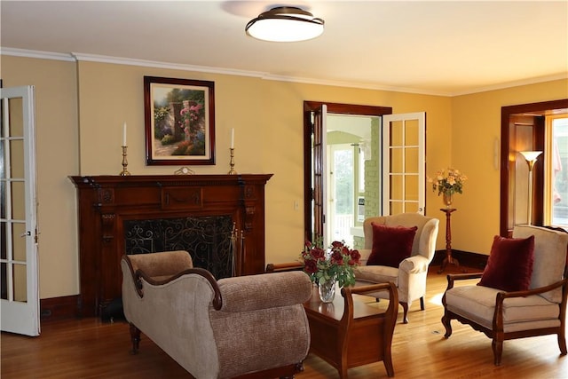 sitting room featuring french doors, a healthy amount of sunlight, crown molding, and hardwood / wood-style floors