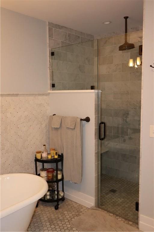 bathroom with tile walls, tile patterned floors, and shower with separate bathtub