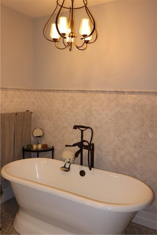 bathroom featuring a tub, tile walls, a notable chandelier, and tile patterned floors