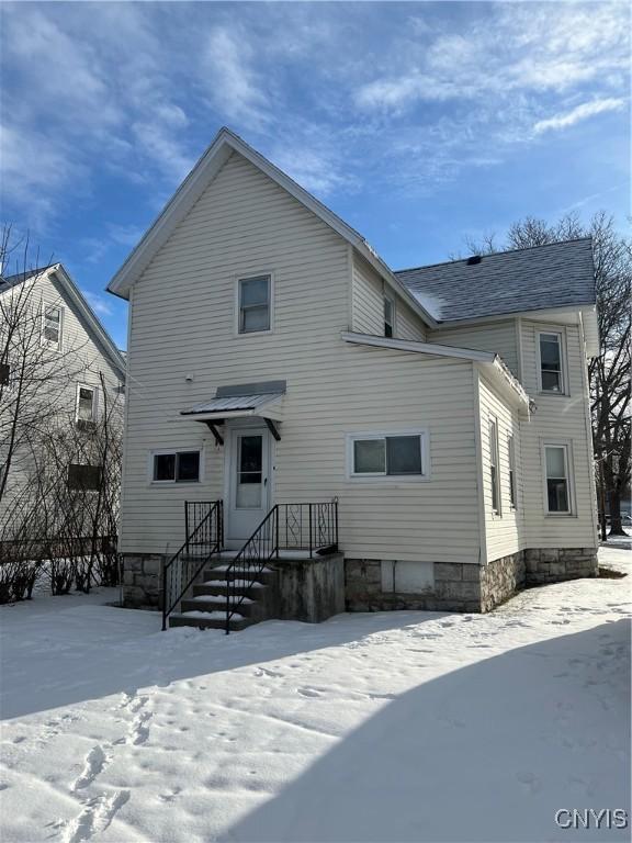 view of snow covered back of property